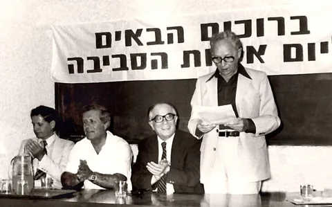 אירוע יום איכות הסביבה ב-1981: נואם עומד ליד שולחן של שלושה משתתפים, ומאחוריהם שלט ״ברוכים הבאים״ ו״יום איכות הסביבה״.