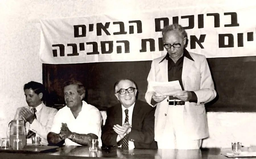 אירוע יום איכות הסביבה ב-1981: נואם עומד ליד שולחן של שלושה משתתפים, ומאחוריהם שלט ״ברוכים הבאים״ ו״יום איכות הסביבה״.